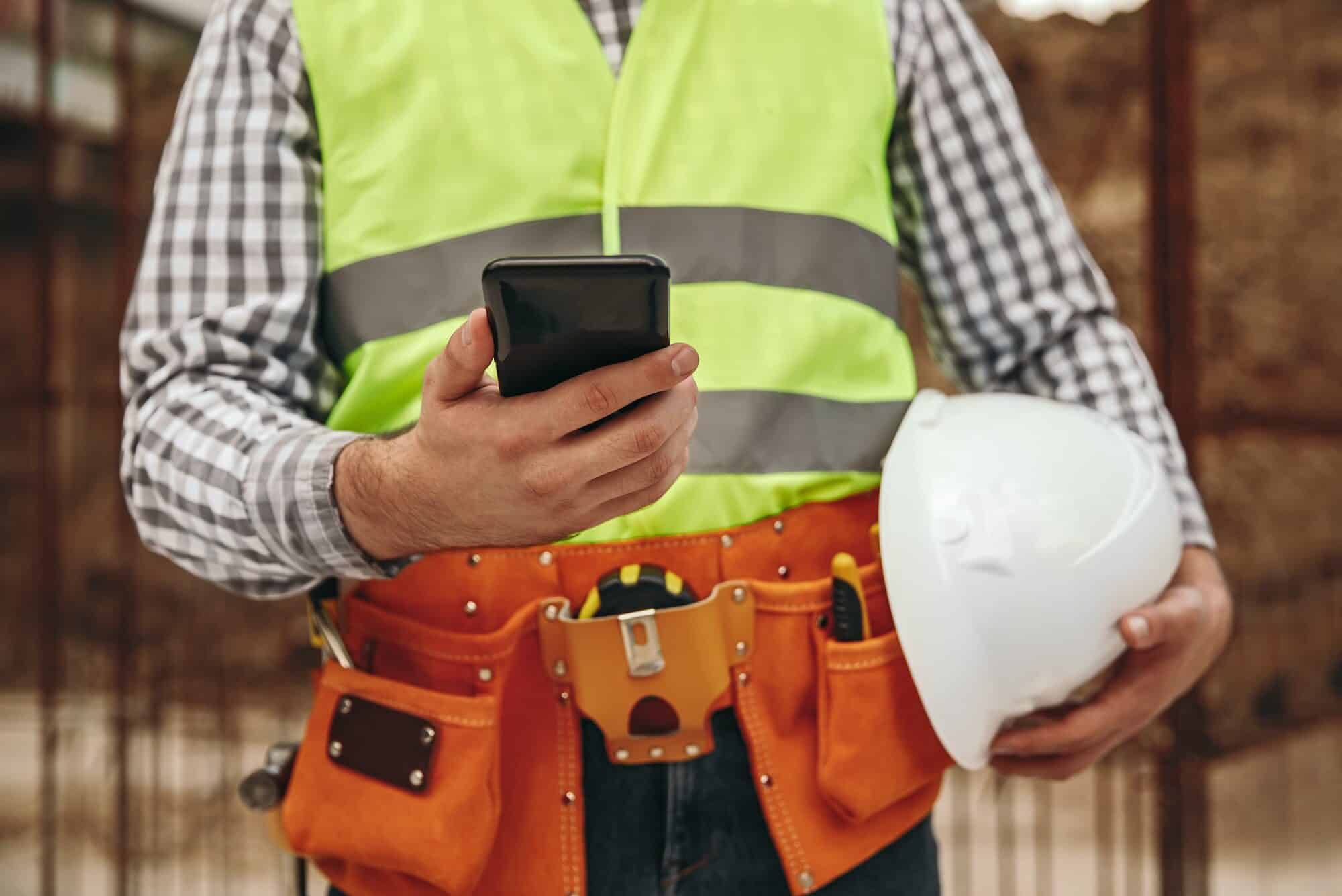 Crop contractor using smartphone during break